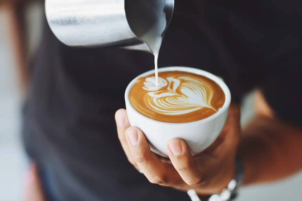 A barista pouring a latte at Taylor Lane Organic Coffee