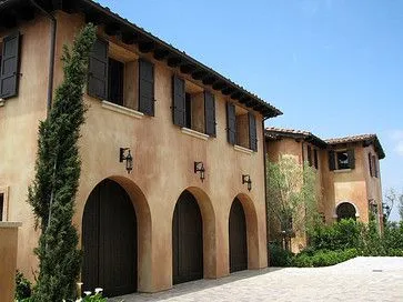 Hand-troweled ochre stucco on a Mediterranean-style elevation by Angel Brothers