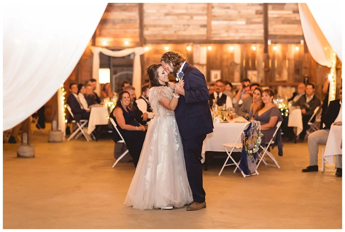 The reception barn set with tables and warm string lights