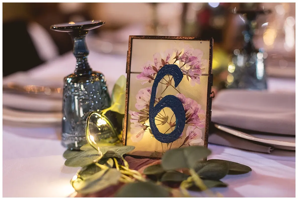 A reception table number and candlelit décor detail