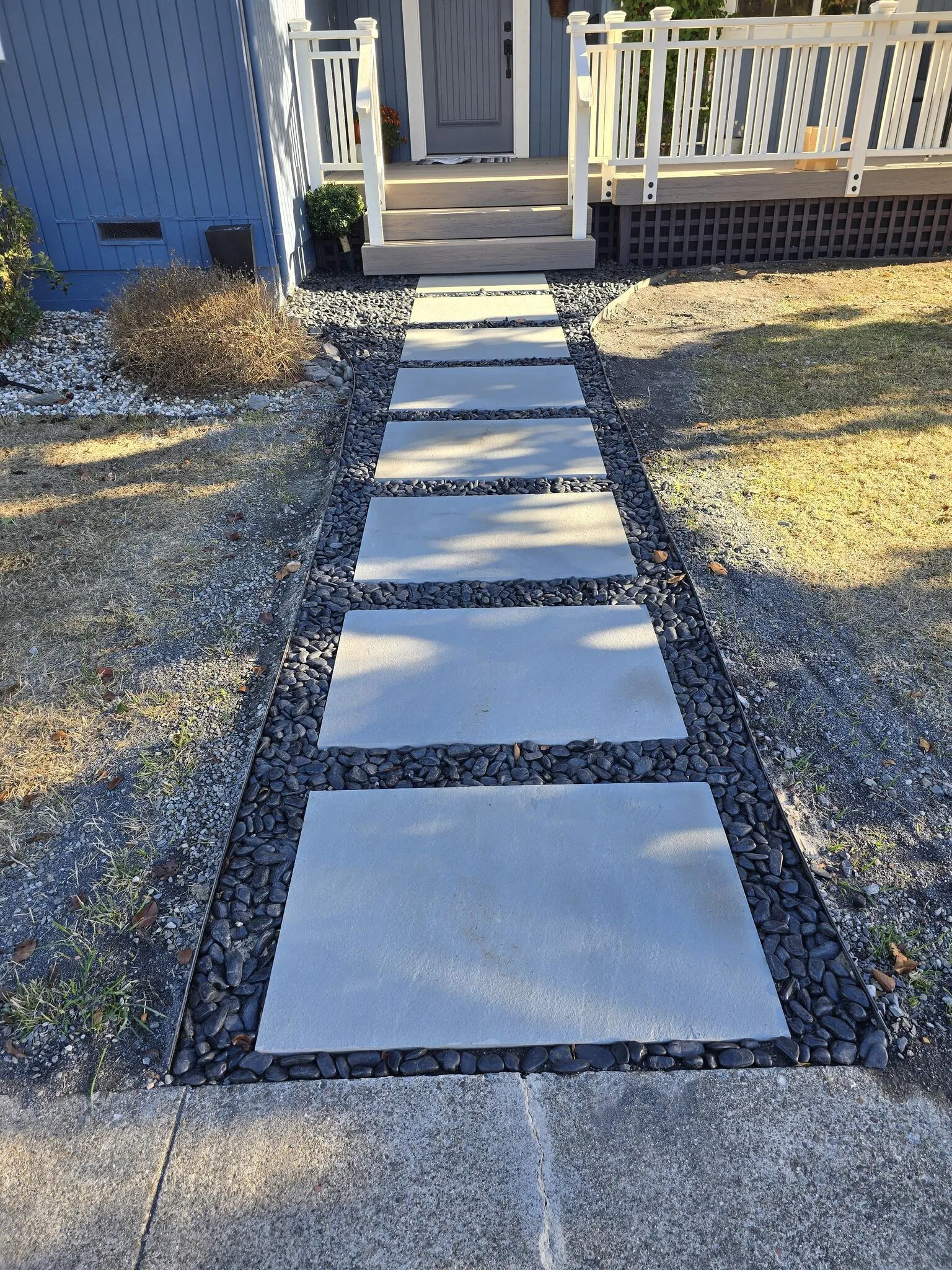 Concrete paver walkway running through a planted garden
