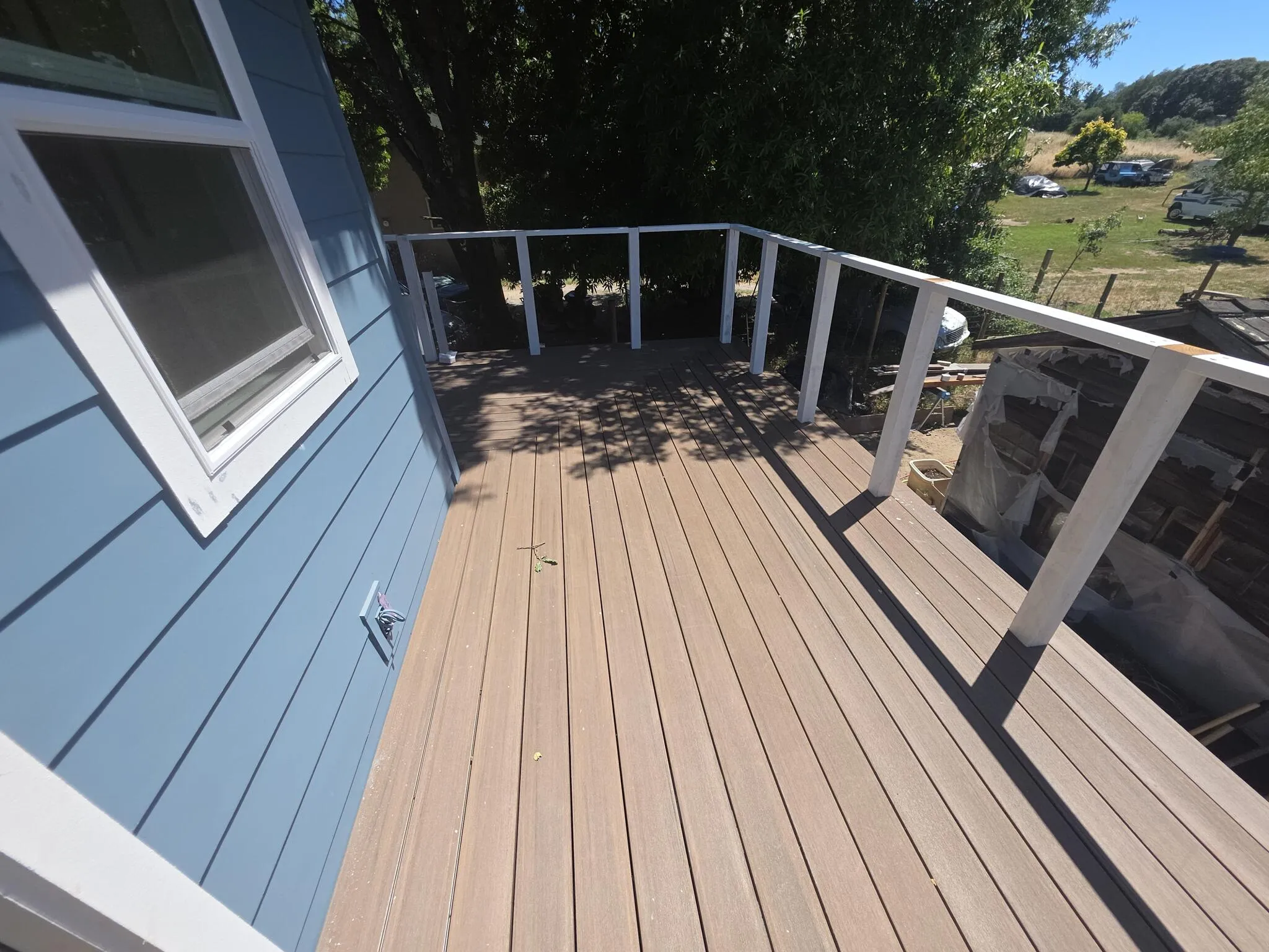 Composite deck boards with picture-frame border and cable railing