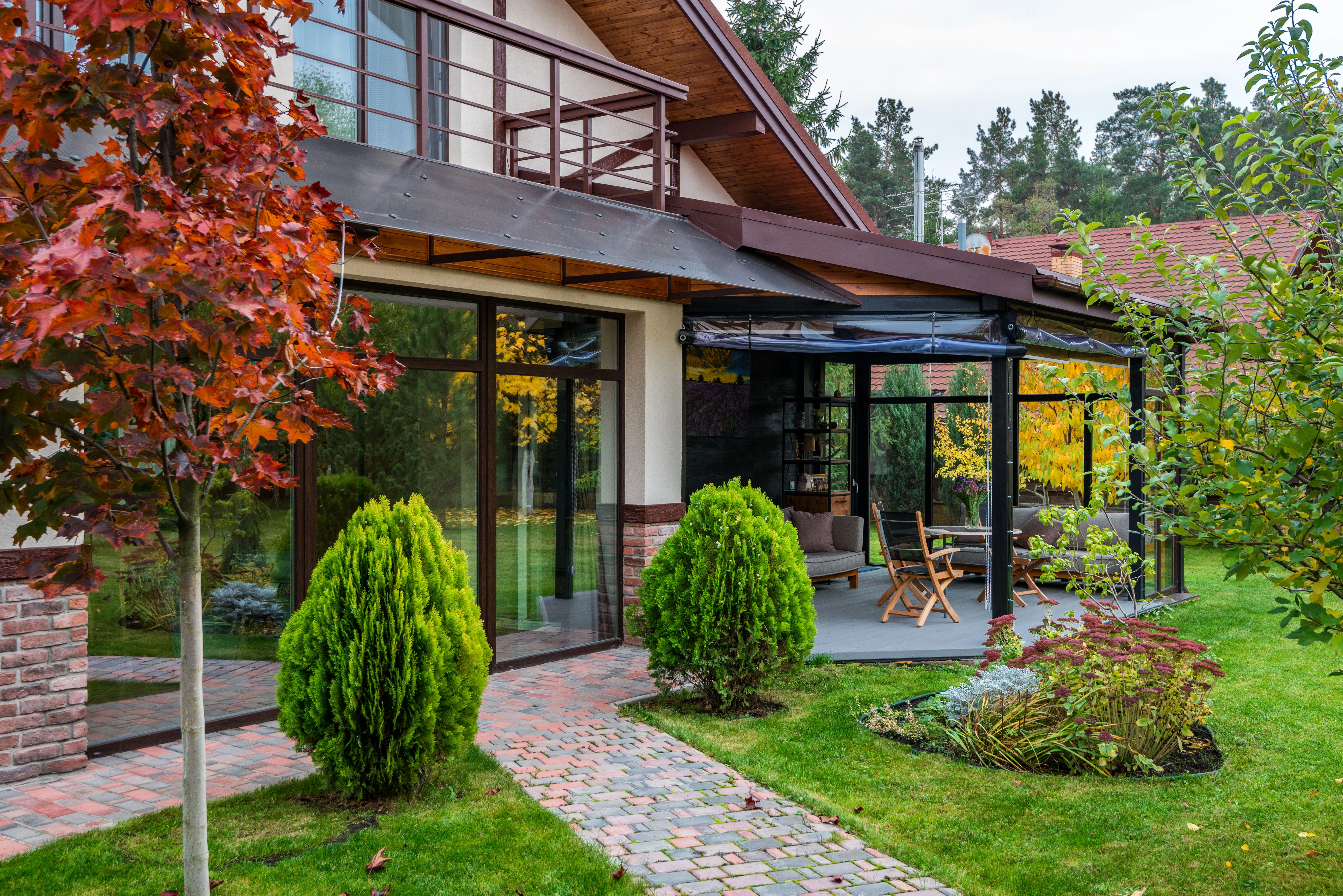 Modern home patio framed by sculpted topiary and lawn