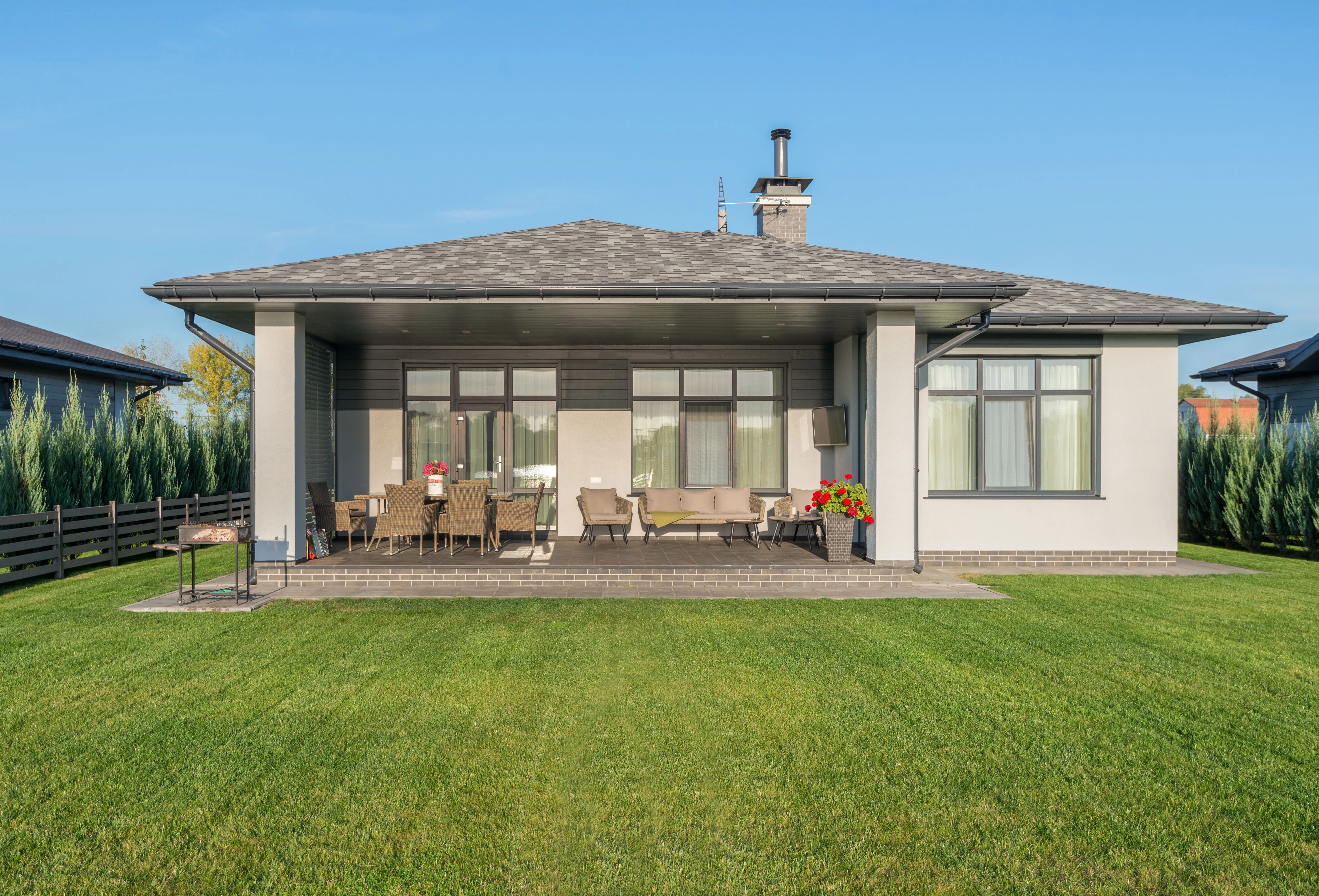Clean striped lawn behind a modern home with a paver patio